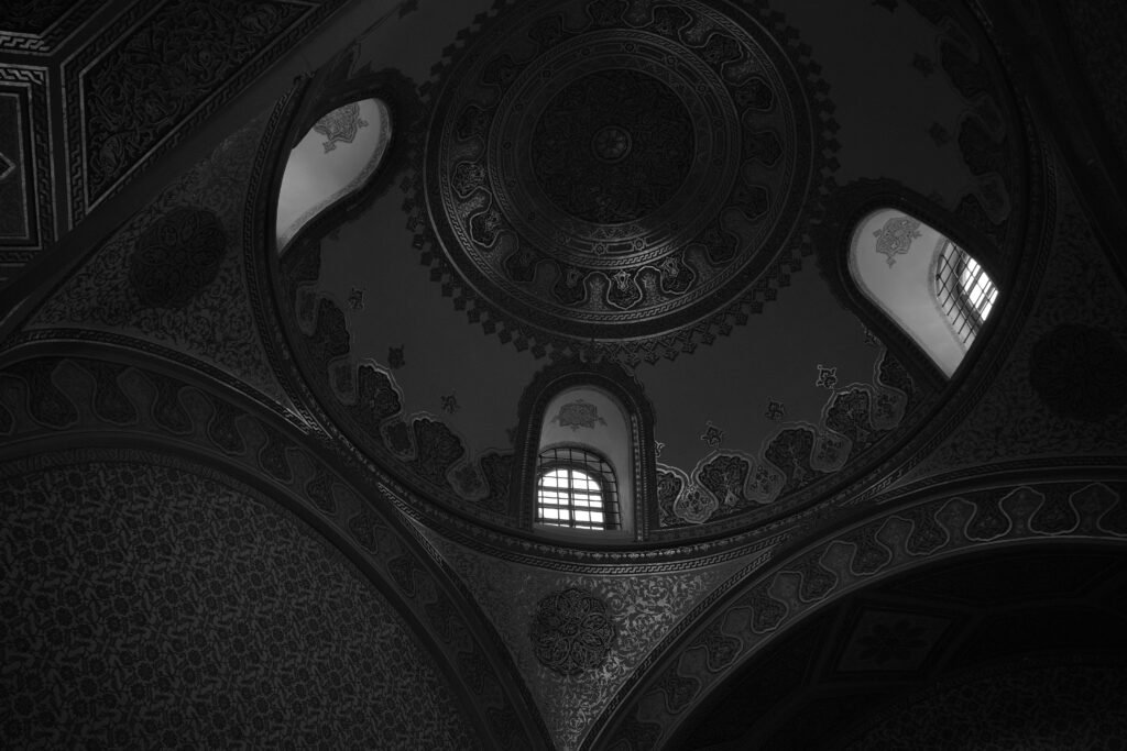 Black and white photo of a beautifully detailed mosque dome interior in Istanbul, Türkiye.